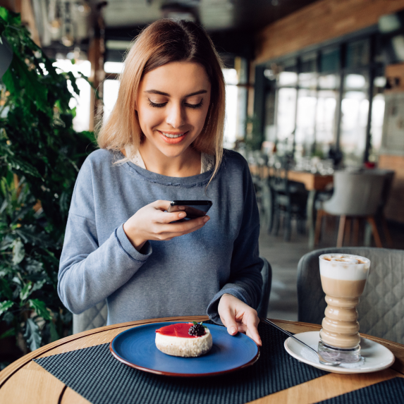 cheerful-nicegirl-taking-photo-tasty-cake-mobile-phone-spending-time-cafe